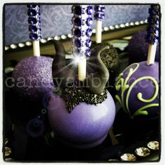 purple cake pops with candles in them on a table