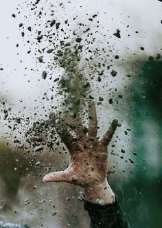 a hand sticking out of the side of a car window covered in dirt and water