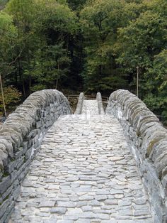 an old stone bridge surrounded by trees