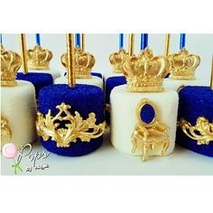 there are many small blue and white cakes with gold crowns on them