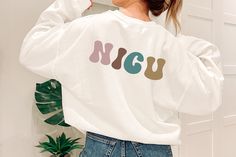 "This cute and colorful NICU nurse crewneck is a perfect way to stay comfortable and stylish while caring for tiny humans! This sweatshirt is the perfect gift for you, your favorite RN, or nursing student! It features a simple design on the front with a stethoscope and \"RN\", and the back reading \"NICU\" in bold colorful text. This crewneck is the ideal choice for any medical professional looking for a reliable, comfortable, and stylish top, on or off the job.   - 50% cotton, 50% polyester - M Casual Crew Neck Nursing Friendly T-shirt, Casual Cotton Sweatshirt For Nursing, Casual White Nursing Tops, Casual Long Sleeve Nursing T-shirt, Casual Nursing Top With Crew Neck, Ohio State Shirts, New Grad Nurse, Nurse Crewneck, Child Life Specialist