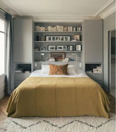 a large bed sitting in a bedroom next to a book shelf filled with books on top of it