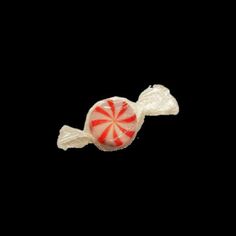 a lollipop candy on a black background with the top half partially covered in frosting