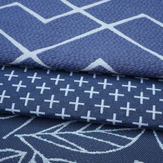 three different types of fabric with white crosses on blue and gray background, close up