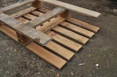 a wooden bench made out of pallets on the ground