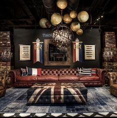 a living room filled with lots of furniture next to a wall mounted mirror and chandelier