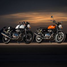 two motorcycles parked next to each other on a road at night with clouds in the background