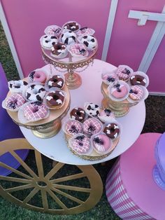 a table topped with lots of cupcakes covered in frosting and toppings