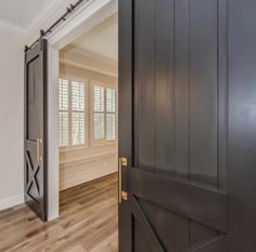 an open door leading to another room with wood floors and white walls, along with hardwood flooring