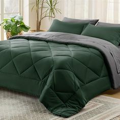 the comforter is green and black in this bedding set, with a plant behind it