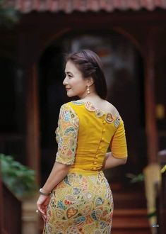 a woman in a yellow dress is standing on the steps and looking off into the distance