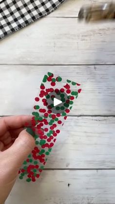 someone is making an origami christmas tree out of paper and colored confetti