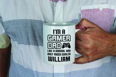 a man is holding a coffee mug that says i'm a gamer dad like a normal dad only much cooler william