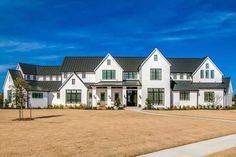 a large white house sitting on top of a dry grass field