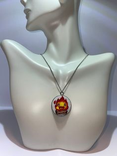 a white mannequin head with a red and yellow necklace hanging from it's neck