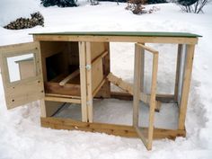 a chicken coop in the snow with its doors open