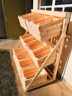 a stack of wooden crates sitting on top of a grass covered field next to a building