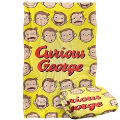 a yellow blanket with monkeys on it and the words curious george written in red letters