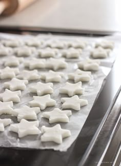 some white sugar stars are on a baking sheet