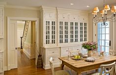 the dining room table is set for two with white cabinets and drawers on each side