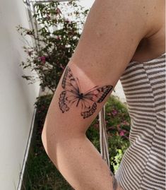 a woman's arm with a butterfly tattoo on the left side of her body