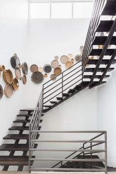 there are many plates on the wall next to this stair case, which is decorated with metal and wood