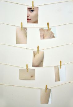 a woman's face is seen through several pieces of paper with clothes pins stuck to it