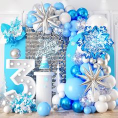 blue and white balloons are arranged in the shape of snowflakes, stars, and numbers