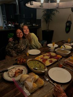 two women sitting at a table full of food