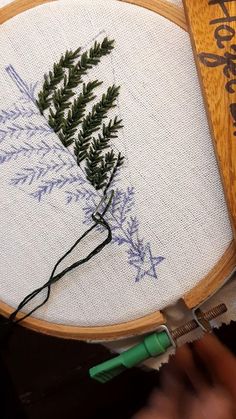 a close up of a cross stitch on a wooden hoop