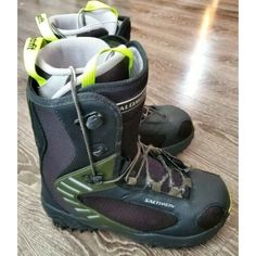 two pairs of ski boots sitting on top of a wooden floor