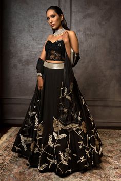 Black lehenga with floral zardozi embroidery, highlighted with pearls and cutdana. Comes with corset blouse and organza dupatta.
Component: 3
Pattern: Embroidered
Type Of Work: Zardozi Floral Motifs
Neckline: Sweetheart
Sleeve Type: Sleeveless
Fabric: Pure Raw Silk, Organza
Color: Black
Other Details: 
Strapless blouse
Tassel hem dupatta
Occasion: Destination Wedding - Aza Fashions Black Art Silk Traditional Wear For Wedding, Black Chanderi Lehenga With Traditional Drape, Black Chanderi Lehenga With Zari Work, Traditional Black Gown For Reception, Black Unstitched Chanderi Lehenga, Festive Black Chanderi Lehenga, Black Art Silk Lehenga For Eid, Eid Black Art Silk Lehenga, Black Cutdana Embroidered Fabric For Traditional Drape