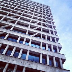 a very tall building with lots of windows on it's side, against a blue sky