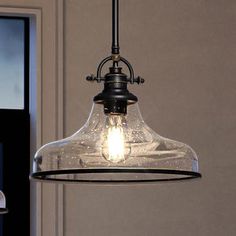 a light that is hanging from a ceiling in a room with a door and window behind it