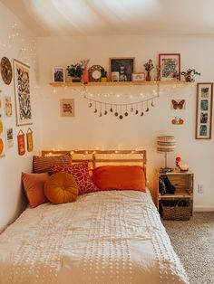 a bed room with a neatly made bed and lots of pictures on the wall above it