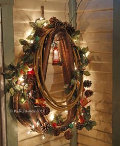 a christmas wreath hanging on the side of a building with lights and decorations around it