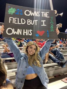 a woman holding up a sign that says, owns the field but i own his