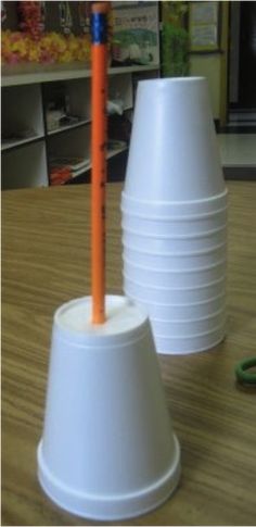 two white cups with orange straws in them