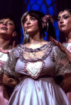 three women in dresses standing next to each other