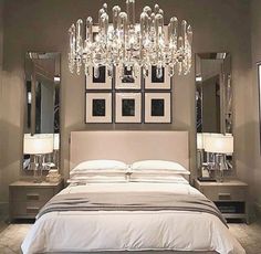 a large bed sitting under a chandelier in a bedroom