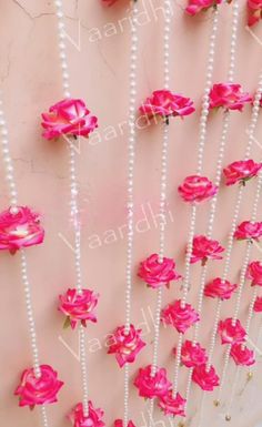 pink roses and pearls are attached to the wall