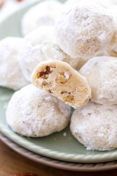 a plate filled with snowball cookies on top of a table