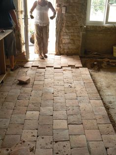 a man is standing in the doorway of an unfinished house with bricks on the floor