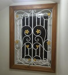 a window that has flowers on it and is next to a wall with a light