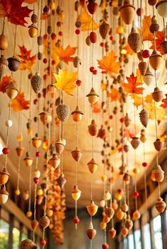 a chandelier with autumn leaves and acorns hanging from it