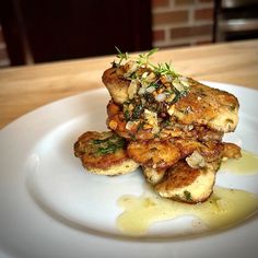 a white plate topped with fried food on top of a wooden table