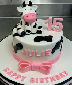 a birthday cake with a cow sitting on top of it and the number fifteen is 15