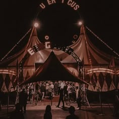 people are standing under a tent at night