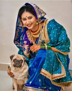 a woman sitting next to a pug dog