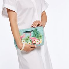 If your dream vacation were a handbag, this would be it. Intricately hand-beaded flamingos step through lush tropical flora on the front of this stunning clutch, while the back features your initials next to spray of palm fronds and bright flowers. With a cutout handle for easy carrying, the luxurious satin interior includes a pocket for small essentials like lipstick or cards. Makes a fantastic gift for birthdays, Mother's Day and more.    9"w x 2"d x 6.5"h  Interior pocket: 3.5"w x 3"h  Glass Palm Fronds, Mark And Graham, Beaded Bag, Beaded Clutch, Everyday Moments, Bright Flowers, Dream Vacation, Cards Sign, Polyester Satin